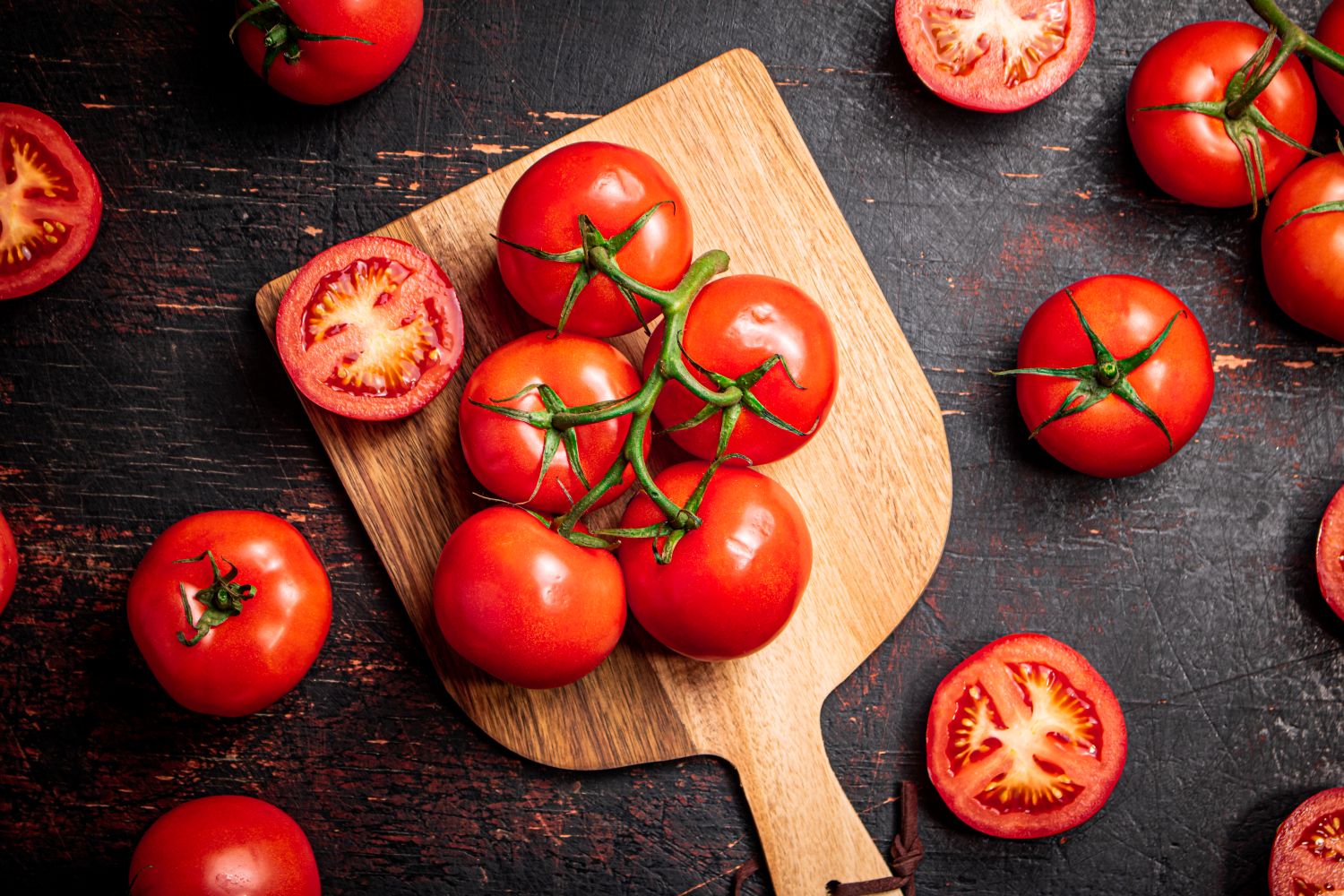 fresh tomatoes on wooden chopping board